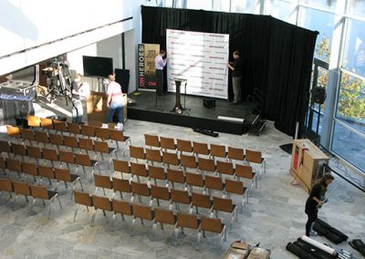Aerial shot of a stage and chairs lined in rows in the Hunter Museum lobby.