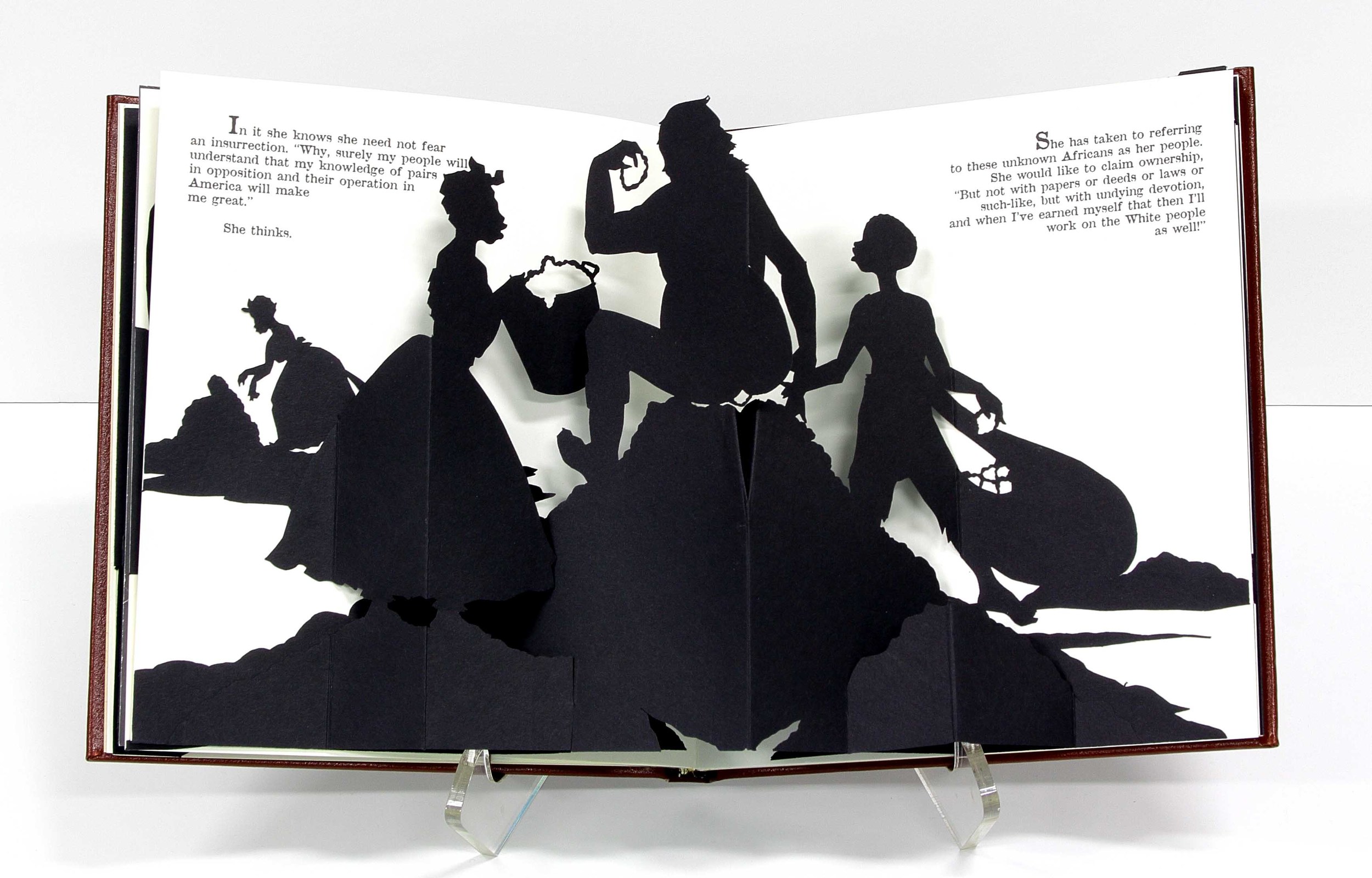 A book with 3D cardstock pop outs of people and mounds on the ground. A person sits on top of a mound with one person offering a bucket and another dragging a sack approaching.