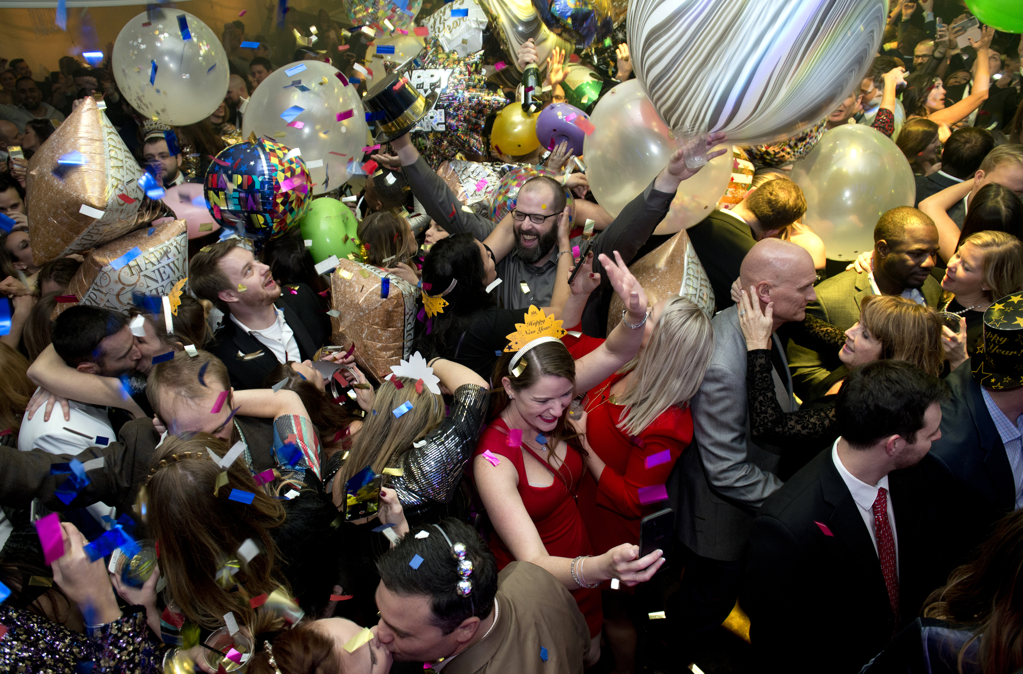 Taken from above, a group of people celebrate with balloons and confetti.