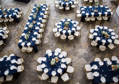 Aerial view of tables with dark blue tablecloths for a wedding reception in the lobby of the Hunter Museum.
