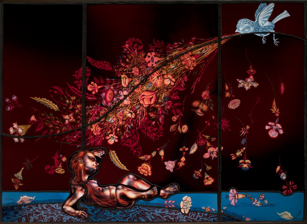 Stained glass of a bird spewing pink hues of flowers out of its mouth onto a person crouching on the blue ground below it.